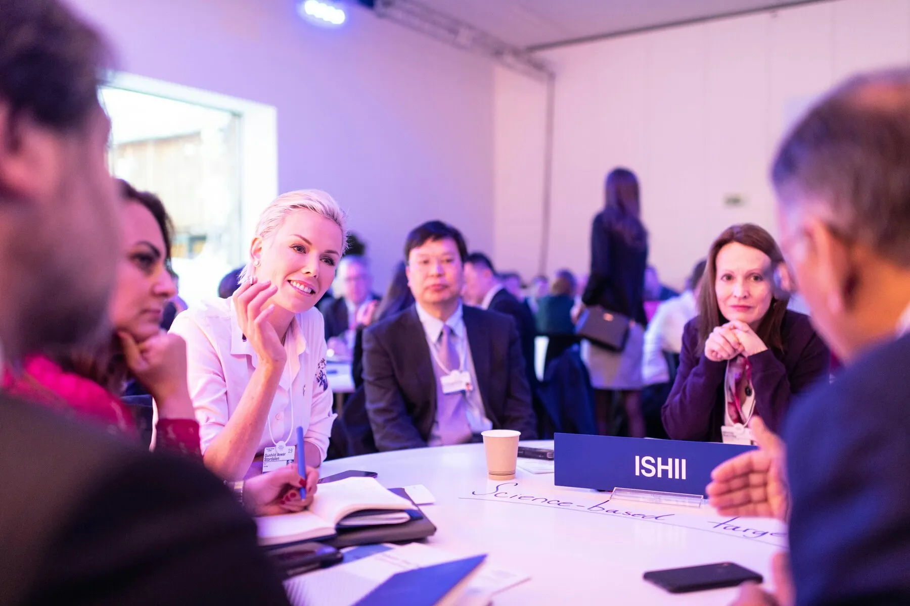 Medewerkers in overleg rond een tafel tijdens een corporate event
